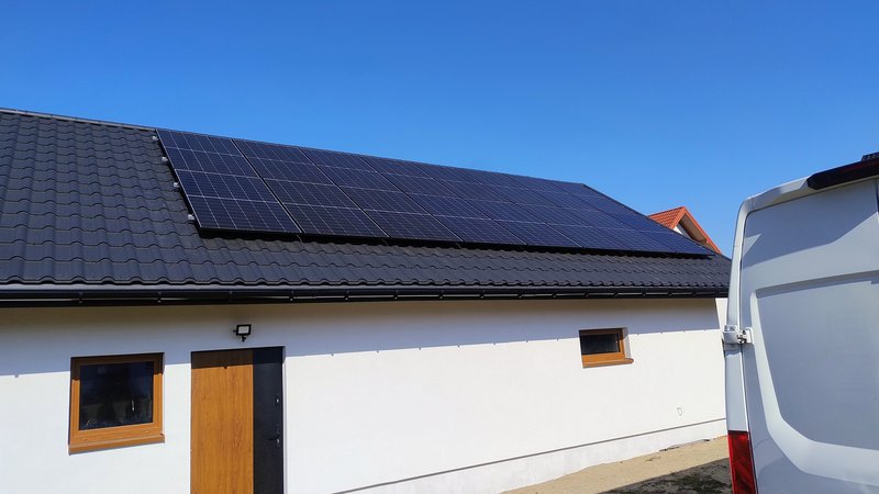 Instalacja fotowoltaiczna na dachu domu z białą elewacją